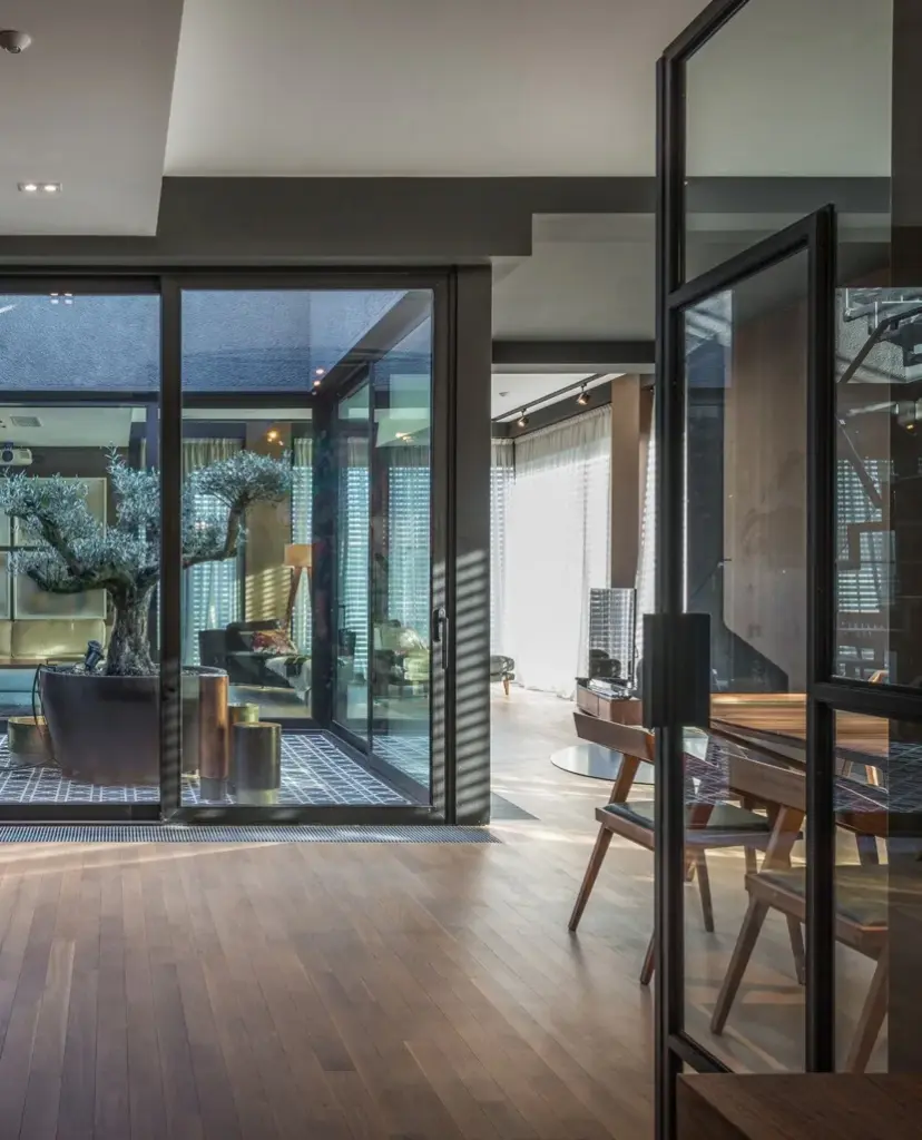 Offene schwarze Stahl-Glas-Tür mit Blick in eine moderne Wohnung